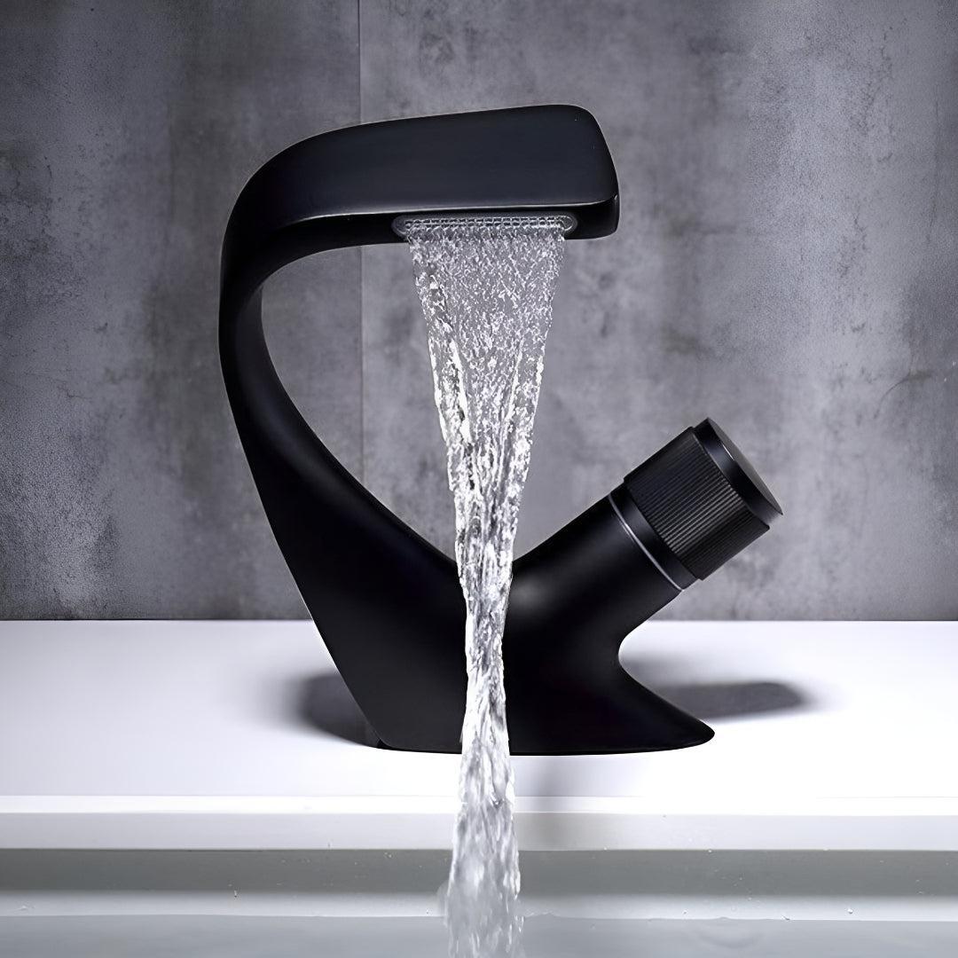 Matte black waterfall bathroom faucet with single-handle mixer, water cascading.