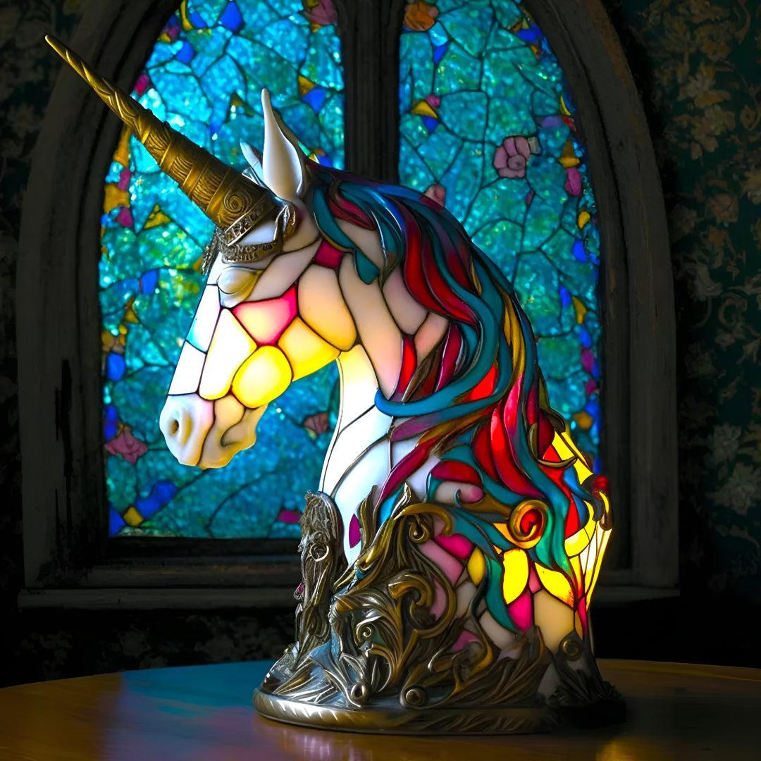Stained glass lamp shaped like a unicorn bust, glowing warmly on a table.